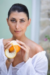 A female beauty peeling an orange